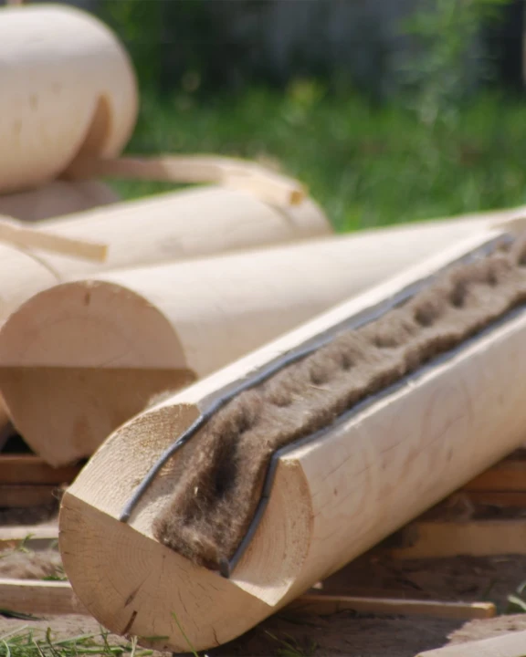 Pas uszczelniający z owczej wełny ISOLENA ułożony w rowku między balami drewnianymi